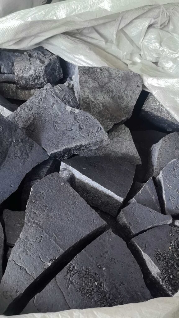 Close-up of ferrosilicon lumps beneath a white bulk bag